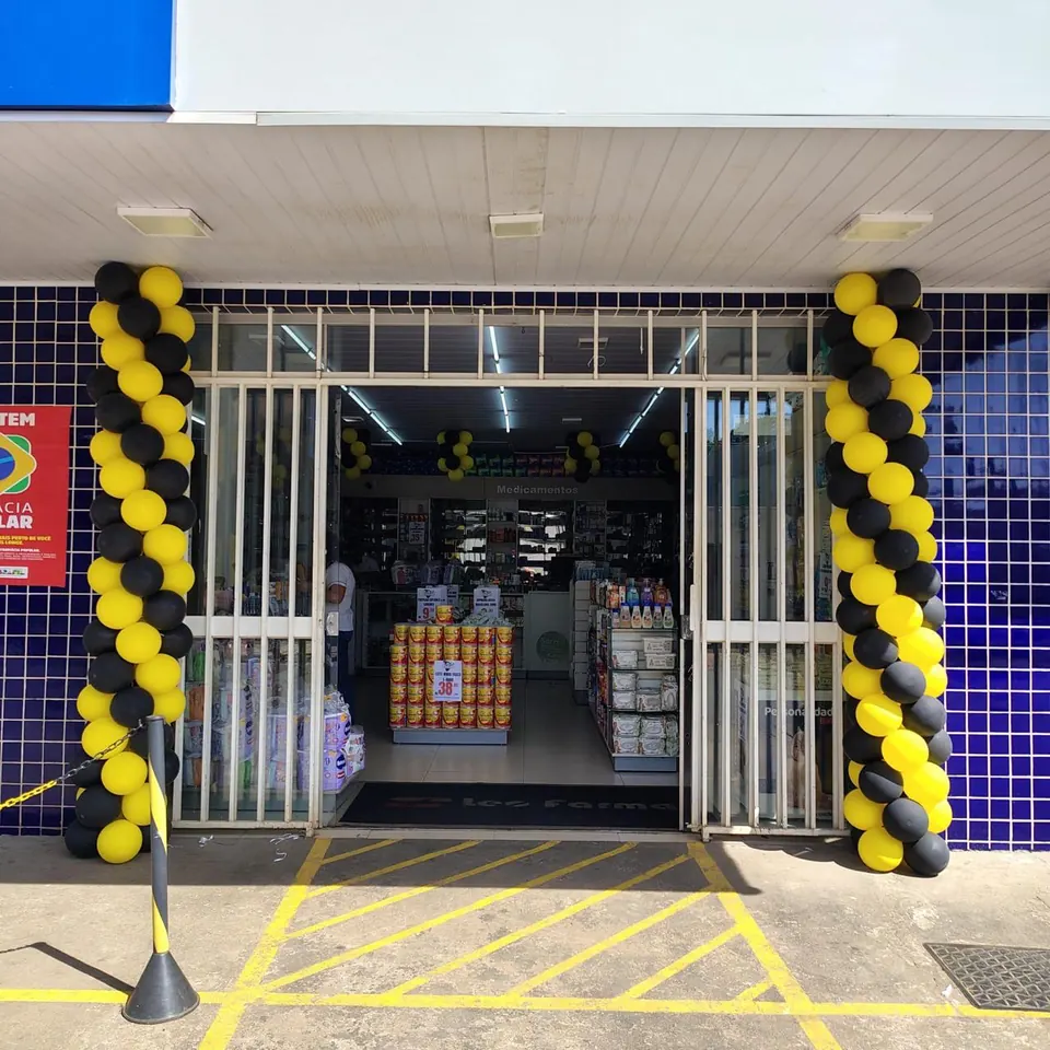 Entrada da Leo Farma, com azulejos azuis e balões amarelos e pretos